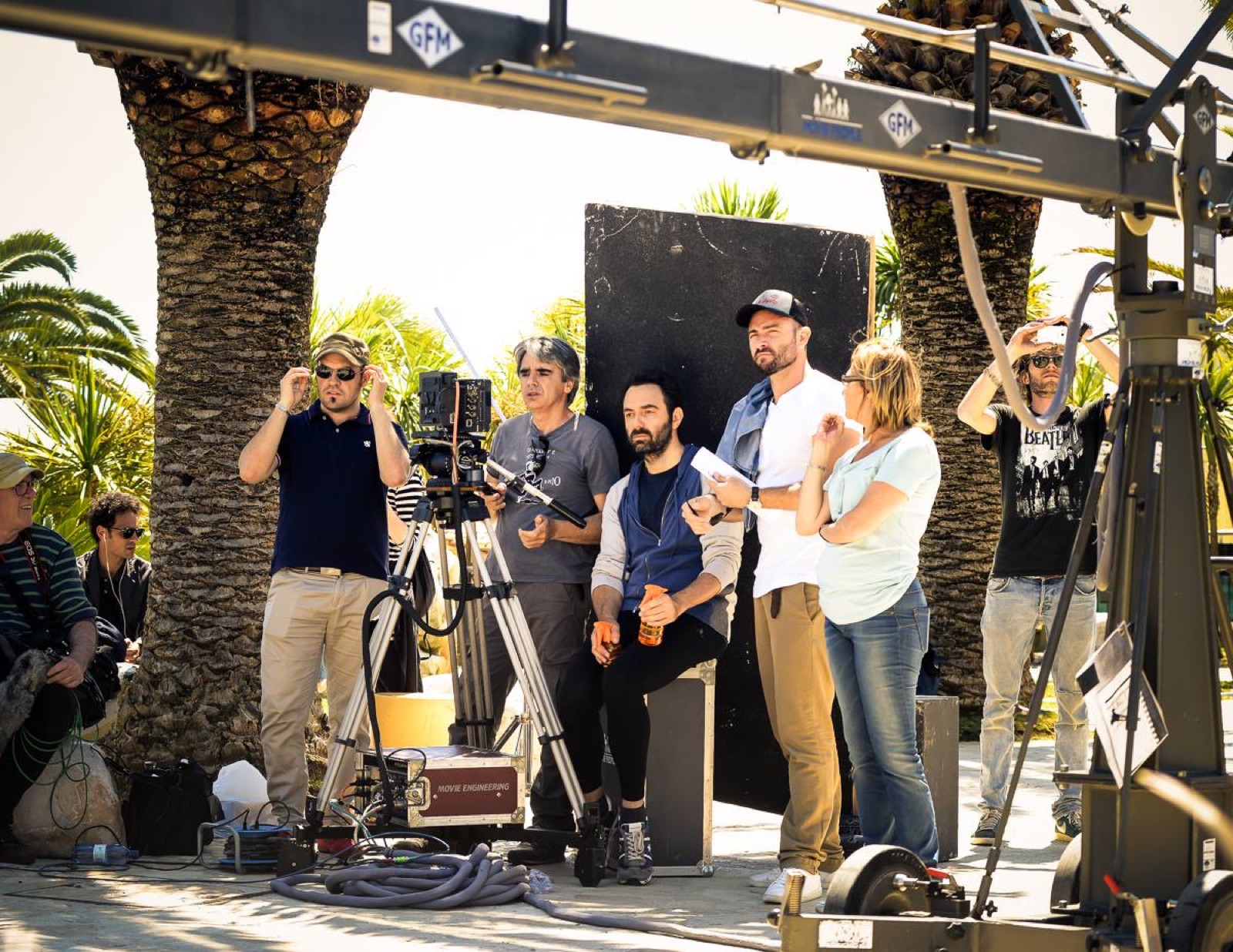 La troupe sotto le palme, con la gru, sul set dello spot Regione Marche